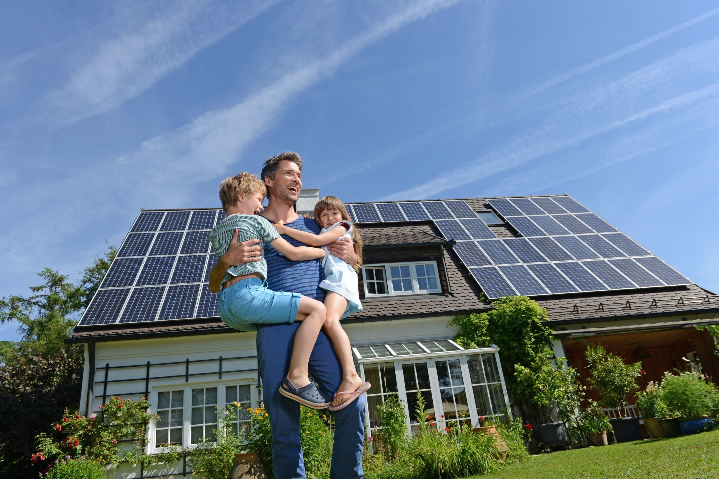 Solar panels on a roof with a city in the background.